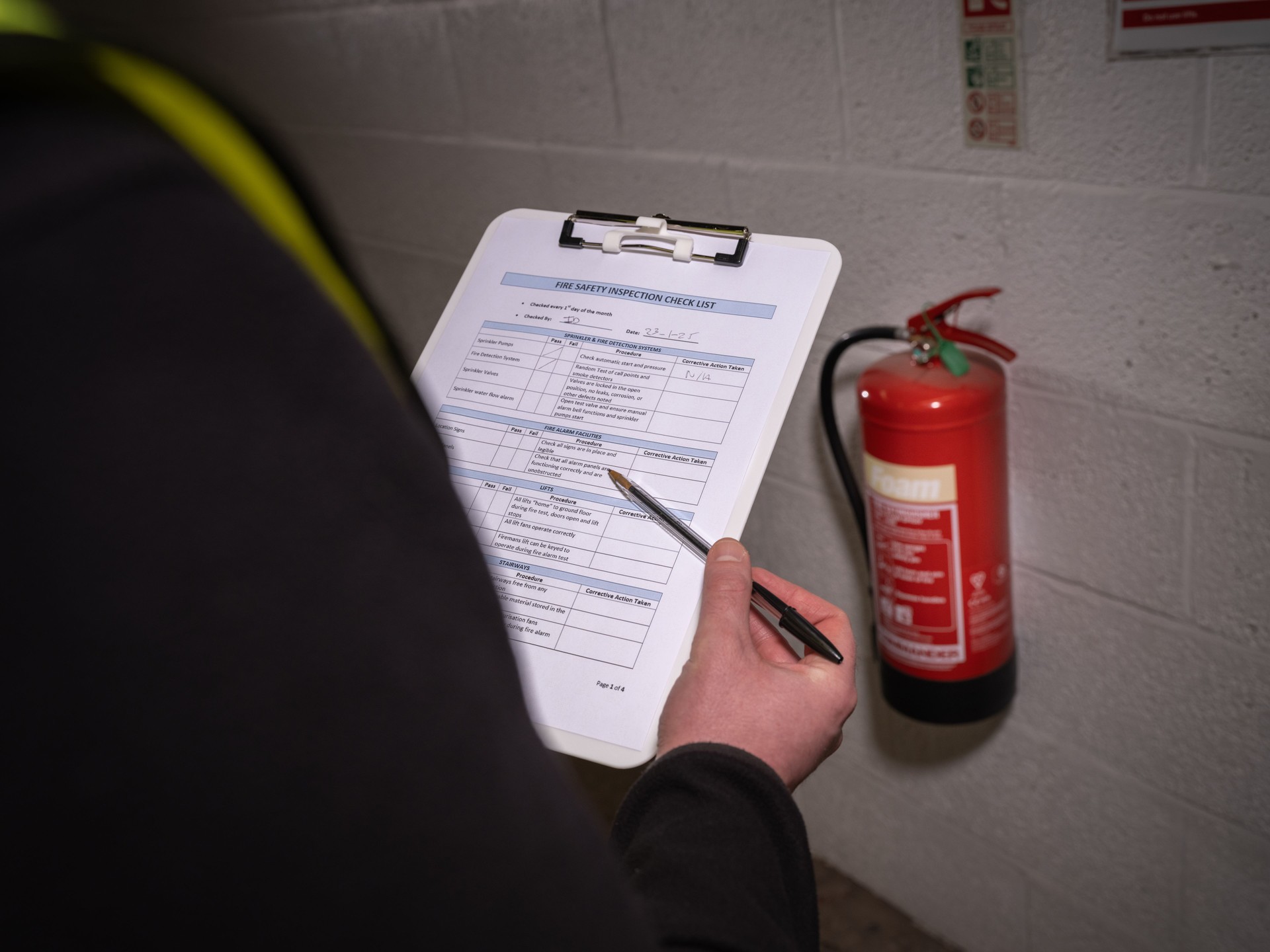 Fire safety checklist with clipboard and visual inspection of fire extinguisher